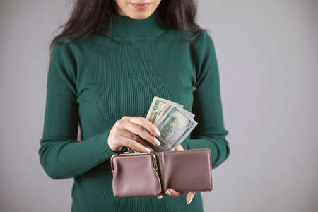 young woman holding wallet with moneyの写真素材