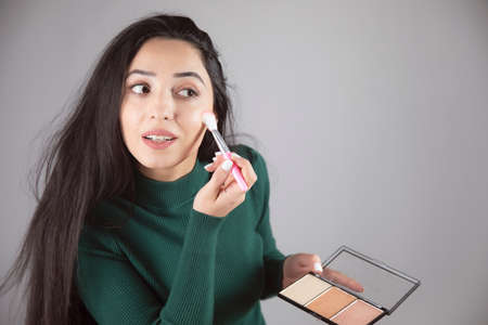 young woman holding brush and highlighter