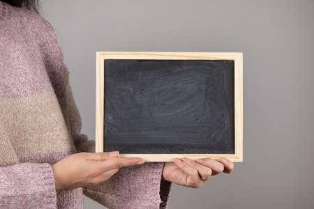 young woman holding chalkboard or blackboard