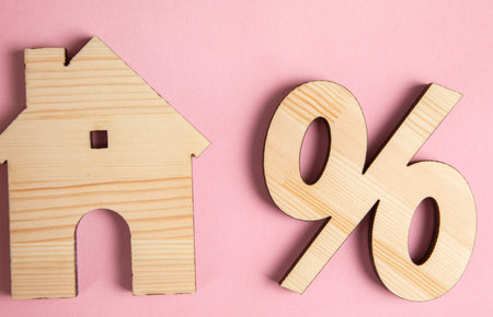 wooden percent sign and house model on tableの写真素材