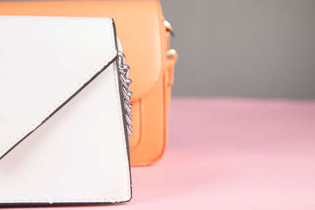 white and orange bag on the pink table