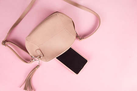 bag with smart phone on pink tableの写真素材