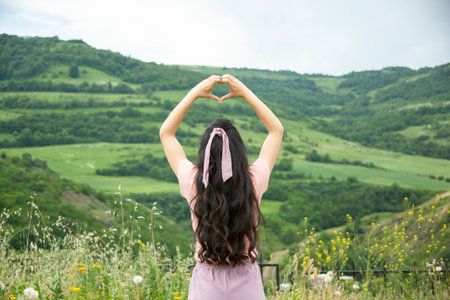 woman hand heart sign in nature background
