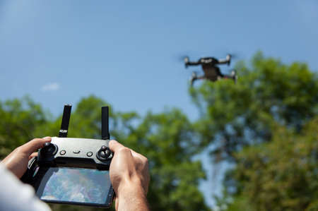 man holding drone remote control in nature