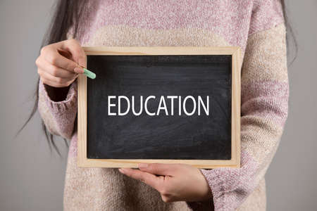 young woman holding education on board