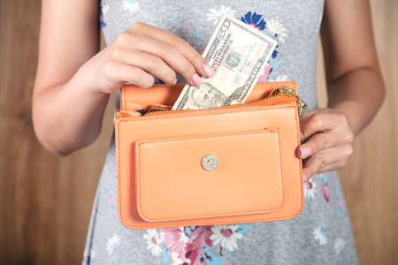 woman holding orange bag with moneyの写真素材