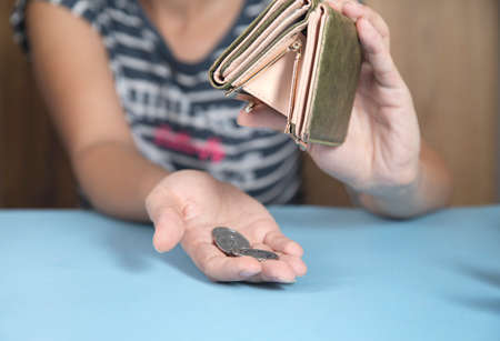 young woman holding wallet and coinsの写真素材