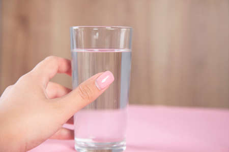 young woman holding glass of water