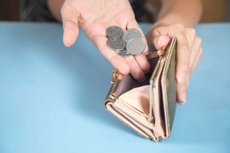 young woman holding wallet and coinsの写真素材