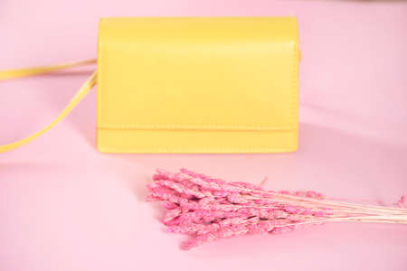 yellow fashion handbag and flower on tableの写真素材