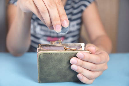 Young woman holding wallet and coins.の写真素材