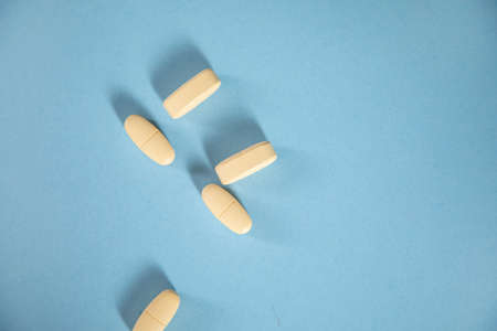 yellow drugs on the blue table background