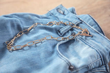 golden necklace on the jeans on the tableの写真素材
