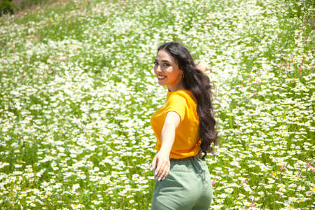 happy young woman in the chamomile fieldの写真素材