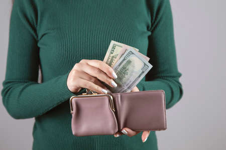 young woman holding wallet with moneyの写真素材