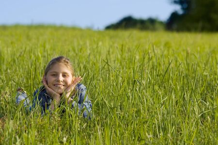 The girl lays on a grassの写真素材
