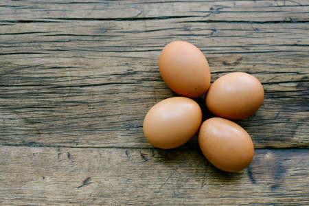 Top view of 4 fresh eggs on a farm table with copy spaceの写真素材