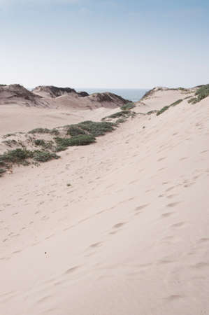 Footprints in the sand dunes and blue sky