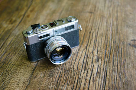 Retro film rangefinder camera on top of a wood table with copyspaceの写真素材