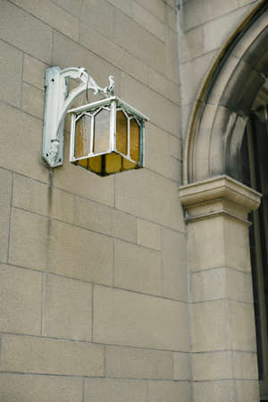 Antique lamp posted on a stone wall of an old churchの写真素材