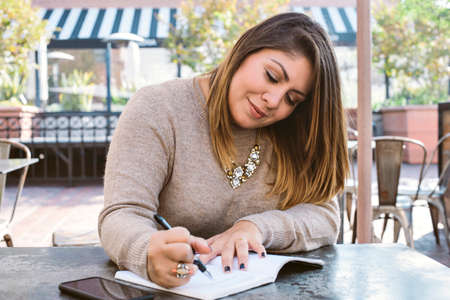 Young girl writes down her goals in a journal