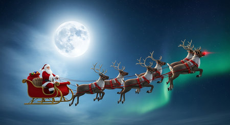 Santa Claus in sleigh pulled by reindeers against full moonの素材