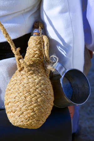 Canteen with wicker cover and ladle for drinkingの写真素材