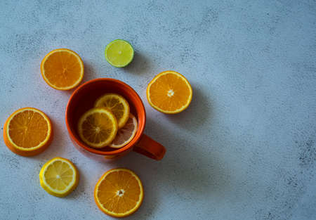 Slices of citrus fruits and orange cup of lemonade on a white background. Horizontal viewの写真素材