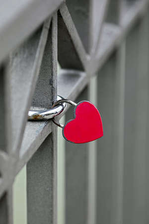 Heart shaped safety lock on a bridge railing sign of loveの写真素材