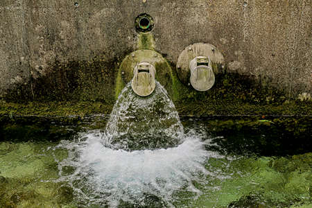 Pipes with running water in riverの写真素材