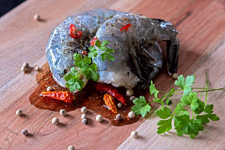 Two prawns ready for cooking seasoned with chilli peppers, pepper Cornes an corianderの写真素材