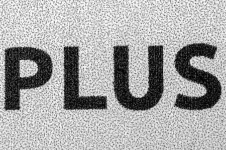 The word PLUS, extreme macro shot of a newspaperの写真素材