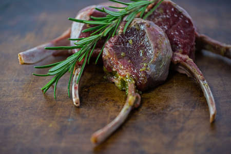 Raw lamb chops with rosemary prepared for roasting on a stone plateの写真素材