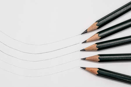 Five pencils with different degrees of hardness and sample line on paperの写真素材