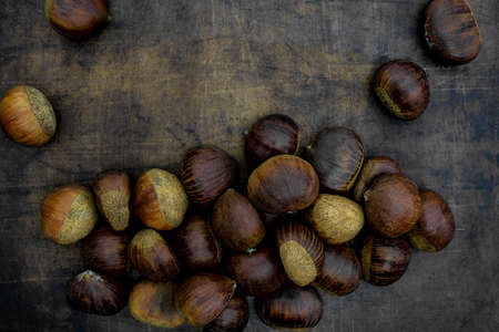 raw sweet chestnuts lying on a stoneware plate, Castanea sativaの写真素材
