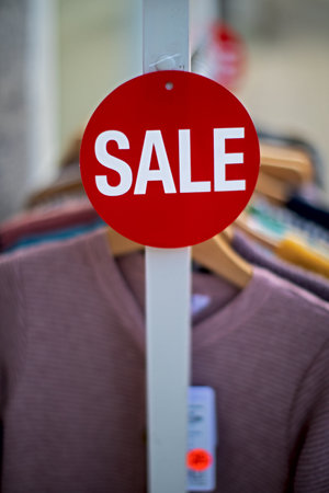 small red sign with white print SALE on a clothes rackの写真素材