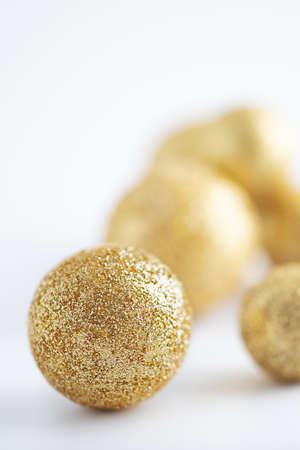 christmas balls covered with golden glitter on white backgroundの写真素材