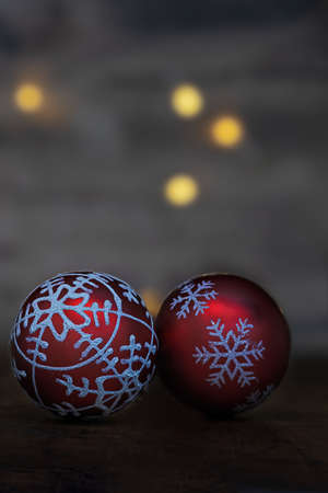 close up of two red glittering christmas baubles in front of a dark backgroundの写真素材