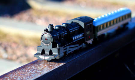 Toy train rides on iron rails, selective focus