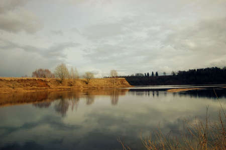 spring river and reflections of trees and clouds in the water, no peopleの写真素材