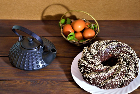 Chocolate bundt cake with sesame seeds on a wooden tableの写真素材