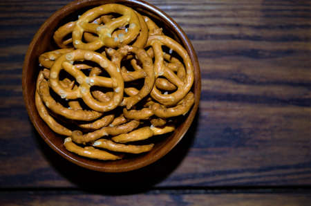 pretzels snack in a wooden bowl on a wooden table top, rustic style