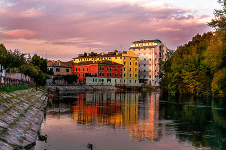 Treviso, the restera esplanade at sunset in autumn. House reflections on the river Sile.のeditorial素材