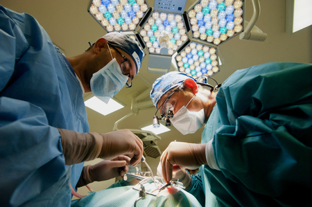 Russia - September 2013: Two surgeons in operating room making plastic surgery on the face.のeditorial素材