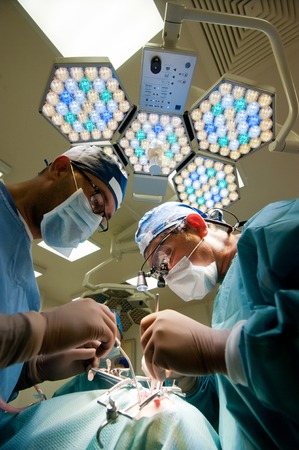Russia - September 2013: Two surgeons in operating room making plastic surgery on the face.のeditorial素材