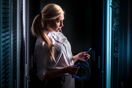 Young engineer businesswoman in network server room. Russia.の写真素材