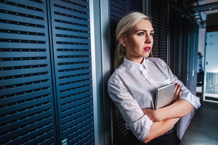 Young engineer businesswoman in network server room. Russia.