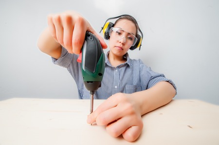 Young woman with a drill at home.