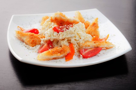 Salad with chicken and tomato in a white dish on black background.の写真素材