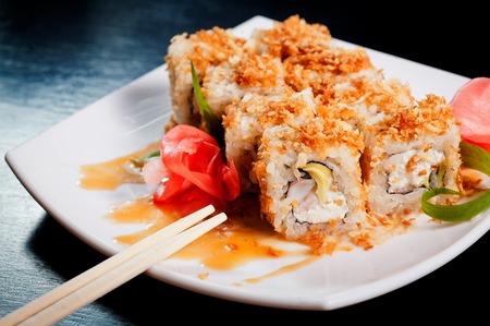 Set of rolls on a white plate on a wooden dark table.の写真素材